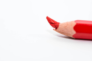 Broken red pencil on focus close up macro shot isolated on white background, space for text.