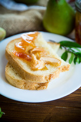 pieces of bread with sweet home-made fruit jam from pears and apples in a plate