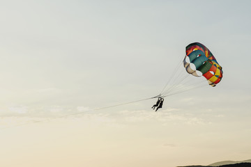 Round parachute against the sunset sky with clouds in an unusual color scheme. Multi-color process.