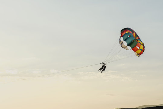 Round parachute against the sunset sky with clouds in an unusual color scheme. Multi-color process.