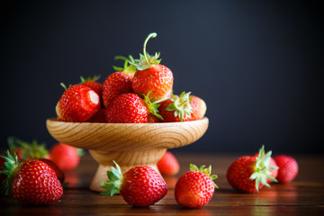 ripe red organic strawberry on a wooden table