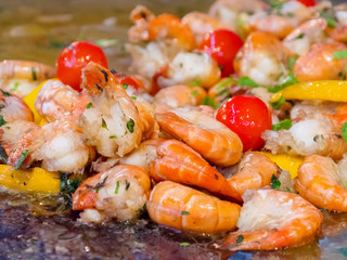 Shrimp preparing with vegetables and herbs close up. Hot shrimp appetizers with herbs and tomato. shrimp with vegetables Mediterranean cuisine, shrimp grilled on a plate.