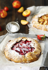 Homemade open pie galette with strawberry and peaches.