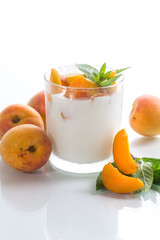 homemade yogurt with ripe apricots on a white
