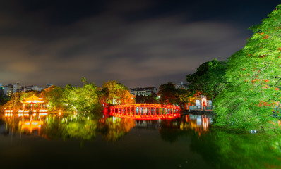 Fototapeta na wymiar OLD QUARTER, HANOI/VIETNAM - JULY 28: Night view of The Huc bridge and Ngoc Son temple on 07 28 2018 in Lake of the Returned Sword, Lake of the Restored Sword, Hoan Kiem Lake. Landmark in vietnamese.
