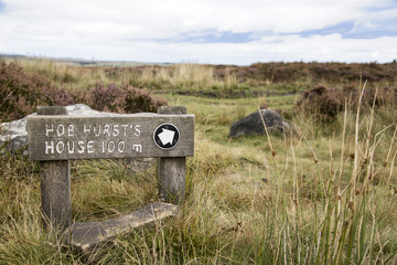 A wooden sign post signifying that is is 100 meters to Hob Hurst`s House in the Peak District