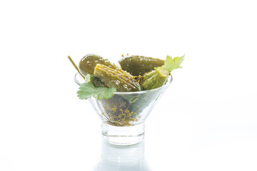 Cucumbers salted in a glass bowl on white background