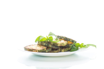 Fried zucchini in a white plate isolated