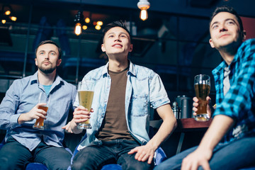 Young men with a beer watching the match in the bar