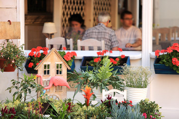 Ludzie przy stolikach w restauracji, kwiaciarnia. - obrazy, fototapety, plakaty