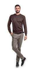 A man in pants and a sweater stands with one leg crossing another on a white background.
