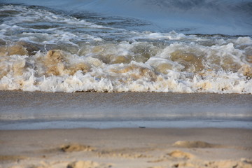 Sandy ocean waves and foam