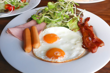 fried egg , bacon , sausage ,ham and vegetable