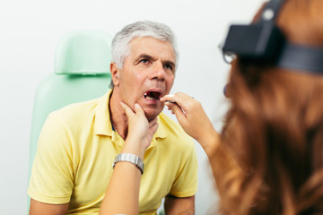 Senior man at medical examination or checkup in otolaryngologist's office
