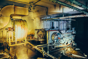 Old rusty diesel generator of air filtration and ventilation system in abandoned Soviet bunker