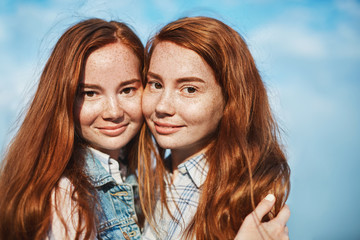 They make puzzle complete together. Good-looking happy female with red hair and freckles, hugging...