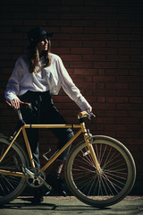 Fototapeta na wymiar Portrait of beautiful brunette holding bicycle.