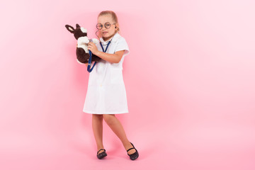 Little girl in doctor costume with toy