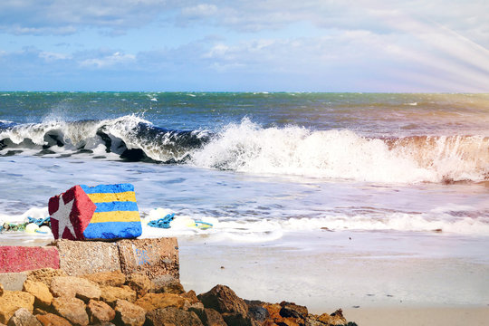 Stein mit aufgemalter Flagge liegt in Tunesien am Strand