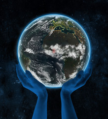 Ghana on night planet Earth in hands