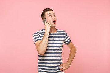 Portrait of fun emotional young man talking on mobile phone, conducting pleasant conversation...