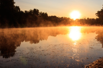 Obraz premium View of river in the mist at sunrise. Fog over river at morning