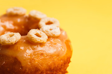 Donut with honey glaze on a yellow background
