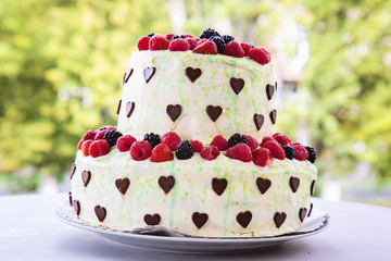 Sweet cake with chocolate hearts and berries