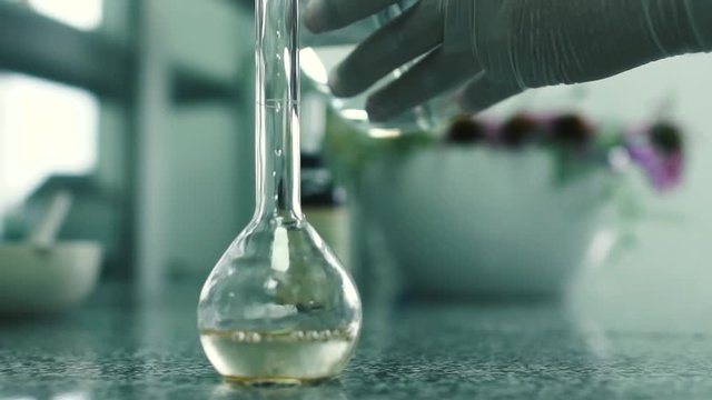 Laboratory assistant pours the water into the flask