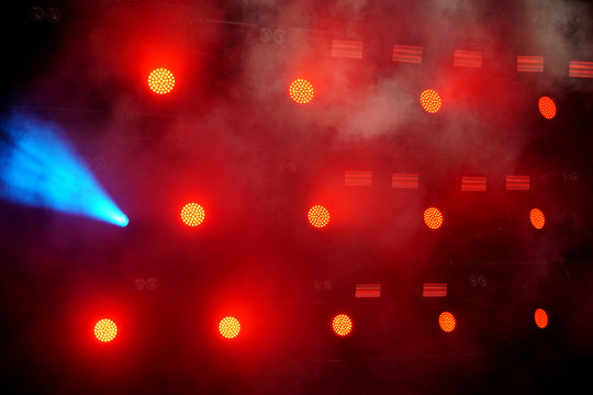 Several red stage lights in the dark