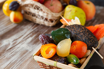 Mix of dried glazed fruits in syrup on wooden background