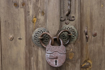 Old rusty opened lock without key. Vintage wooden door, close up concept photo. Security, metal.