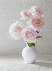 pink roses in vase on white background