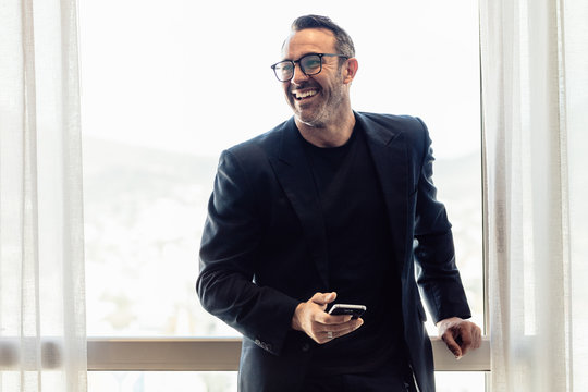 Middle Aged Man In Business Suit Looking Away And Smiling