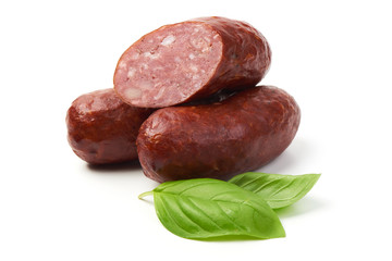 Bratwurst smoked pork sausages with sausage slices and green fresh basil leaves, isolated on white background.