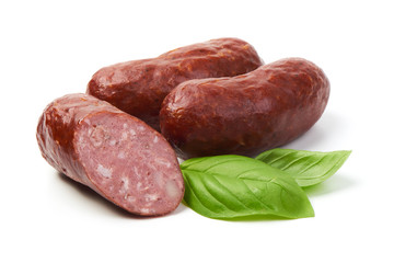 Bratwurst smoked pork sausages with sausage slices and green fresh basil leaves, isolated on white background.