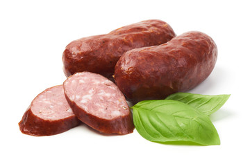 Bratwurst smoked pork sausages with sausage slices and green fresh basil leaves, isolated on white background.