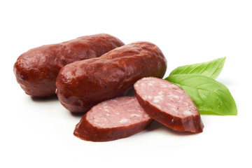Bratwurst smoked pork sausages with sausage slices and green fresh basil leaves, isolated on white background.