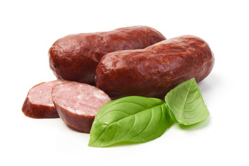 Bratwurst smoked pork sausages with sausage slices and green fresh basil leaves, isolated on white background.