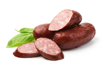 Bratwurst smoked pork sausages with sausage slices and green fresh basil leaves, isolated on white background.