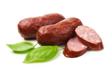Bratwurst smoked pork sausages with sausage slices and green fresh basil leaves, isolated on white background.