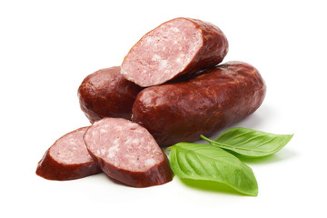 Bratwurst smoked pork sausages with sausage slices and green fresh basil leaves, isolated on white background.