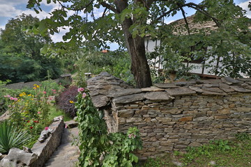 Stone house with stone fence in the Village of Leshten. Historical, facade. The Village of Leshten...