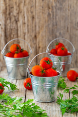 Cherry tomatoes in the bucket on old wood background
