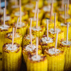 appetizing, baked corn on the cob and wooden stick. crisp, crunchy, juicy, sexy, tasty