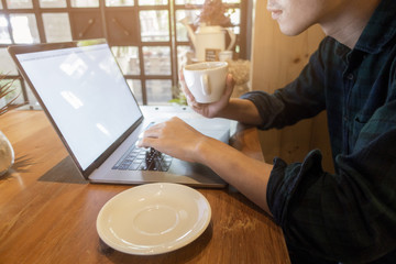 Close up young man working with his computer in coffee shop