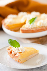 Traditional shortcrust pastry lemon tart with citrus custard and whipped cream