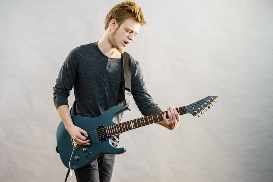 Young man playing electric guitar