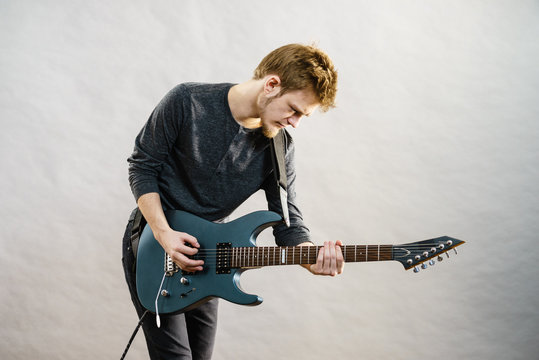 Young man playing electric guitar
