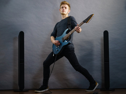 Young man playing electric guitar